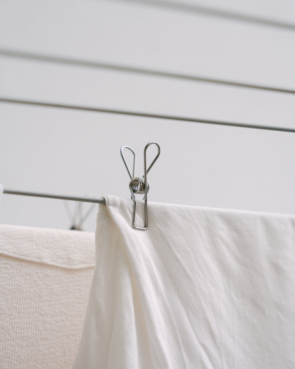 Forever Pegs marine-grade stainless steel peg holding a white sheet on a clothesline