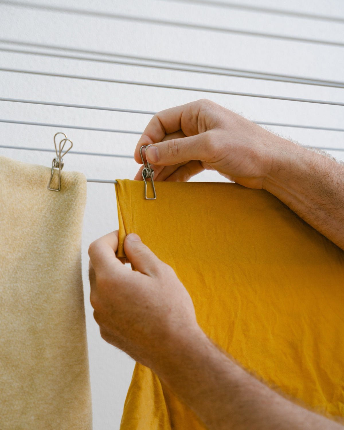 Pegging a mustard top to the clothesline with a Forever Peg