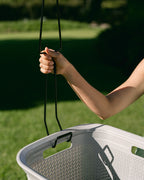 Clipping a Hang Easy Basket Hanger onto the handle of a washing basket